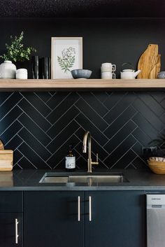 a kitchen with black tile and wooden shelves