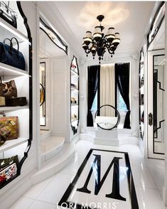 a white room with black and white flooring and chandelier hanging from the ceiling