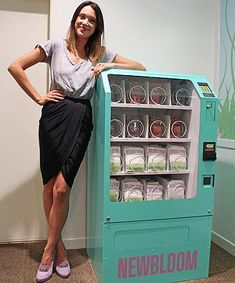 a woman standing next to a vending machine