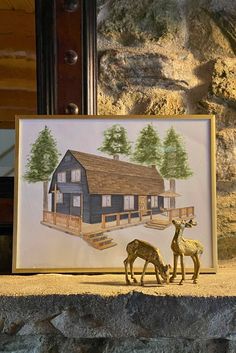 two deer are standing in front of a painting on the wall next to a house