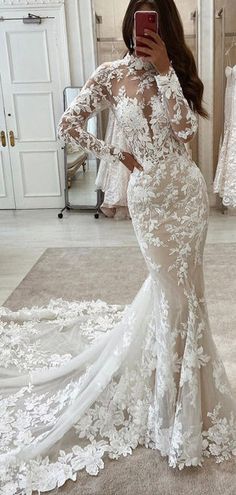 a woman is taking a selfie in her wedding dress while looking into the mirror