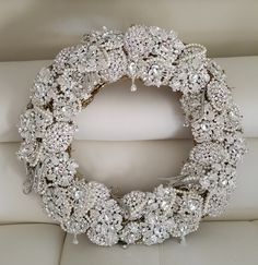 a white couch with a wreath made out of crystal stones on the back of it