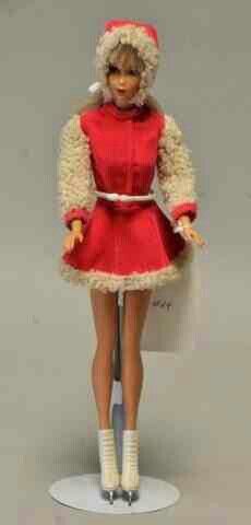 a barbie doll is wearing a red dress and white boots with a hat on her head