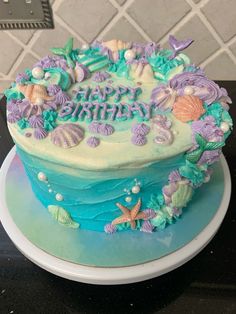 a birthday cake decorated with sea shells and seashells