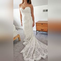 a woman in a white wedding dress posing for the camera