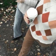 a woman holding a cup of coffee in her hand