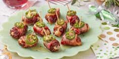 bacon wrapped jalapeno pop bites on a green plate next to condiments