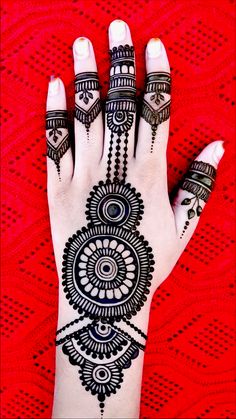 a woman's hand with henna tattoos on it and her hands painted in black