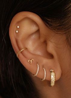 a woman wearing three different ear piercings on her left and right side of the ear