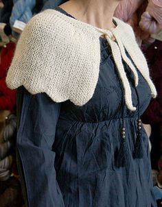 a woman standing in front of a pile of clothes