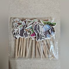 several stickers with cartoon characters on them sitting in a plastic bag next to some toothbrushes