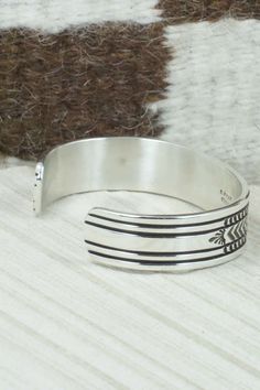 This sterling silver and bracelet was made by Navajo silversmith Bruce Morgan. The inside is signed B. Morgan and stamped sterling.Size: 5 1/4" (will fit up to a 6 3/8" wrist)Gap: 1 1/8"Width: 1/2"Free shipping on all orders! We ship with USPS and always include tracking. All orders ship within a day of payment.Returns are accepted up to 30 days after you receive your order. Just send us a message. Our shop offers cash back or store credit. The item must be returned in new condition. Southwestern Sterling Silver Polished Bangle Bracelet, Southwestern Sterling Silver Bangle With Polished Finish, Adjustable Silver Southwestern Bangle, Southwestern Polished Sterling Silver Bangle, Adjustable Southwestern Silver Bangle, Southwestern Stamped 925 Cuff Bangle Bracelet, Southwestern Sterling Silver Cuff Bracelet In Silver, Artisan Sterling Silver Bracelet With Inlay, Southwestern Sterling Silver Cuff Bracelet