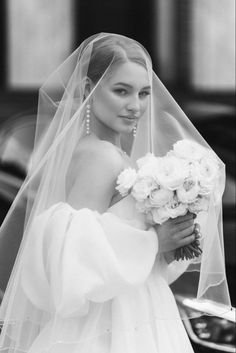 black and white photograph of a woman in a wedding dress with flowers on her bouquet