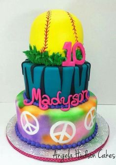 there is a colorful cake decorated with baseballs and peace signs on the bottom tier