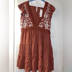 I Have 2 Short Brown/Orange Flowey Dress, Floral Embroidered Brand New From Francesca’s Never Worn One With Tags And One Without Orange Embroidered Summer Dress, Orange Sleeveless Dress With Floral Embroidery, Orange Embroidered Short Sleeve Dress, Sleeveless Orange Dresses With Floral Embroidery, Brown Cotton V-neck Mini Dress, Short Flowy Dress, Flowey Dress, Flowy Dress Short, Dresses Short