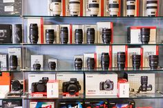 the shelves are full of different types of cameras and books on display in a store