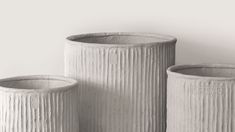 three white vases sitting next to each other