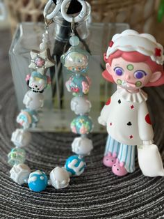 some little figurines sitting on top of a table next to a glass bottle