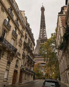 the eiffel tower is in the distance from some old buildings on this street