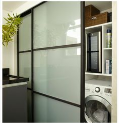 a washer and dryer in a room next to a wall with glass doors