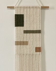 a woven wall hanging on a white wall