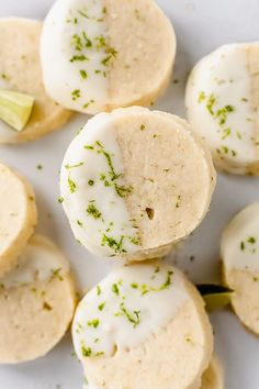 small cookies with white icing and green sprinkles are arranged on a plate