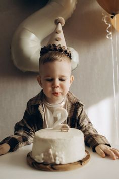 a little boy sitting at a table with a cake