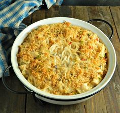 a casserole dish with noodles and vegetables in it on a wooden table top