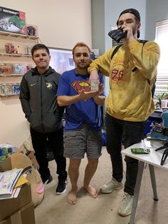 three men are standing in a room and one is taking a photo