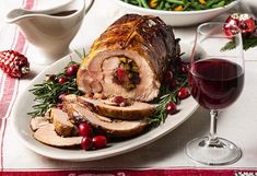 a turkey with cranberry sauce on a plate next to a glass of wine