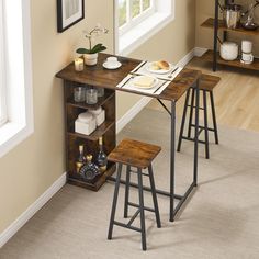 a small table with two stools next to it in the corner of a room