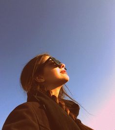 a woman wearing sunglasses looking up into the sky