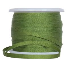 a spool of green ribbon on a white background