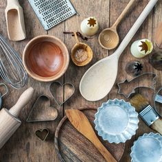 various kitchen utensils and wooden spoons on a table