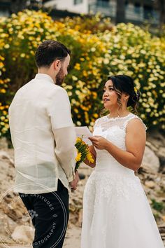 the bride and groom are exchanging vows at their wedding ceremony in front of yellow flowers