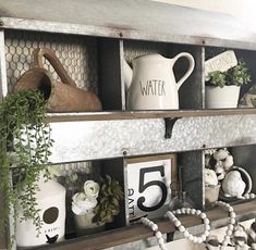 a shelf filled with lots of different items on top of a wall next to a plant