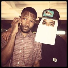 two men with hats on their heads are posing for the camera and one is holding a cell phone to his ear