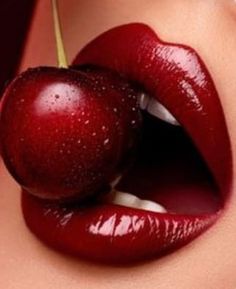 a woman's lips with an apple sticking out of her mouth and water droplets on the lip