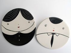 two plates with faces painted on them, one is wearing a suit and the other has a tie