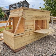 a wooden chicken coop sitting on top of gravel