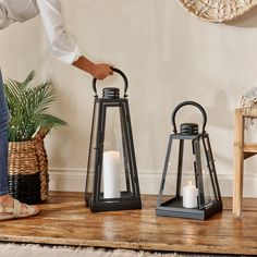 two black lanterns sitting on top of a wooden table