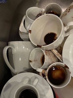 there are many cups and saucers on the table with different types of coffee in them