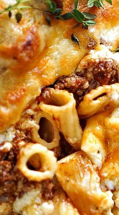 a close up view of some pasta and sauce on a white plate with green garnish