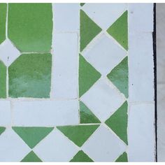 a green and white tiled floor with squares