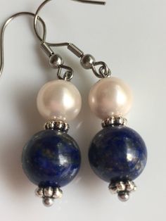 "A 10mm Lapis lazuli gemstone with 8mm ivory shell pearls, this earrings about 2\" long top to bottom, and it's made with stainless steel Hypoallergenic. Hand made jewelry." Nickel-free Blue Pearl Earrings Gift, Blue Pearl Dangle Earrings, Handmade Blue Pearl Earrings, Round Pearl Earrings, Gemstone Earrings Dangle, Earrings Dangling, Pearls Earrings, Earrings Classic, Lapis Lazuli Gemstone