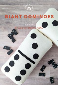 two dominos made out of felt sitting on top of a wooden table with black and white polka dots