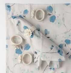 blue flowers and white dishes on a floral table cloth