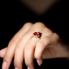 a close up of a person's hand with a ring on their finger,