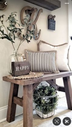 a wooden bench topped with pillows and a vase filled with flowers next to a sign that says happy