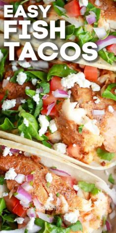 three fish tacos with lettuce, tomatoes and feta cheese on top